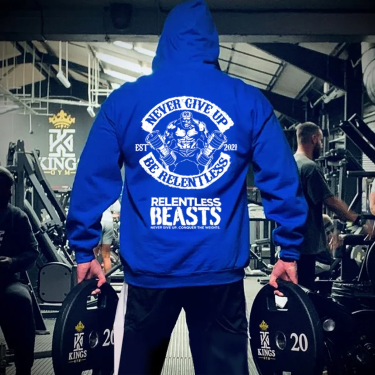 Person in a blue hoodie lifting weights in a gym, hoodie reads 