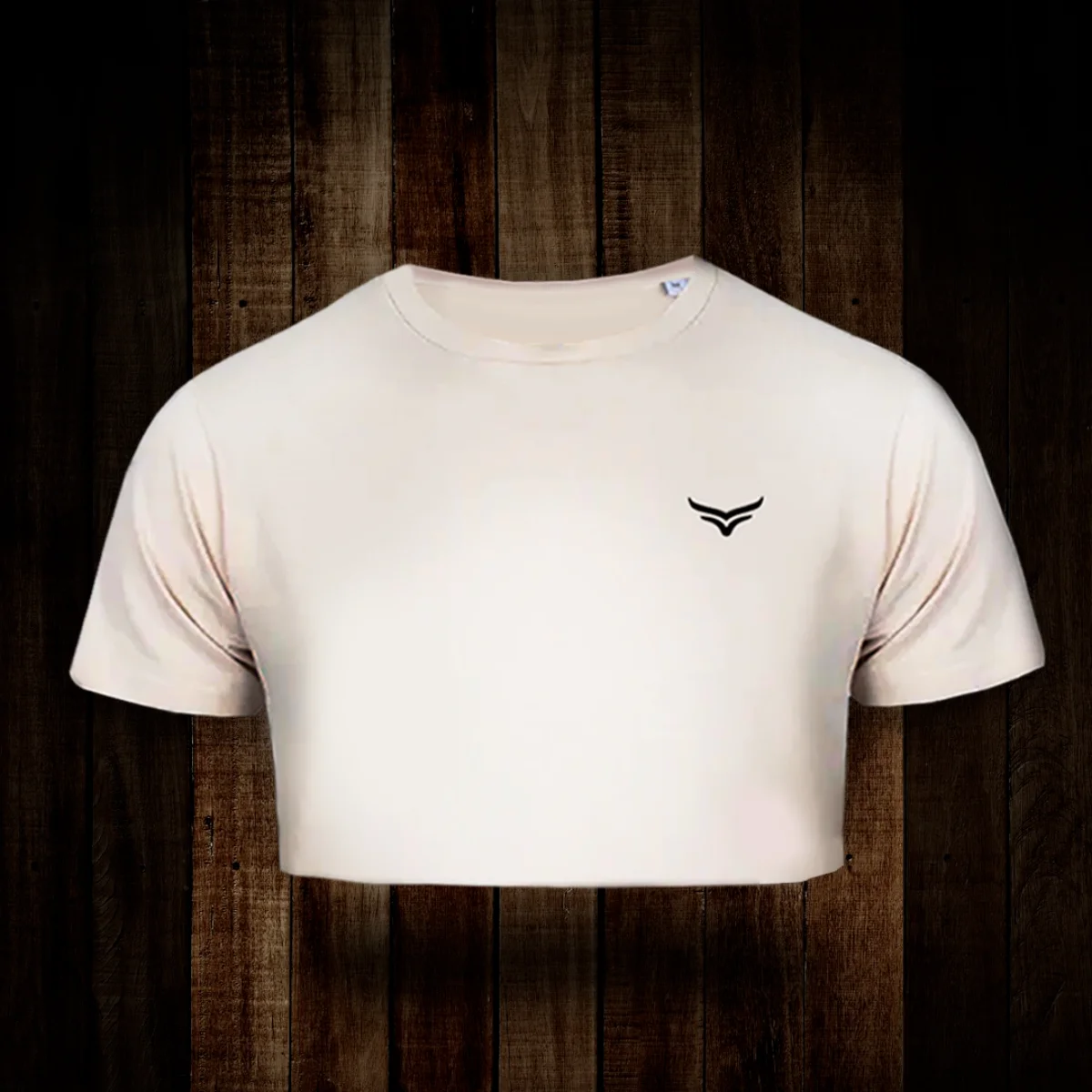 White cropped t-shirt with a small black bird logo, displayed against a dark wooden background.