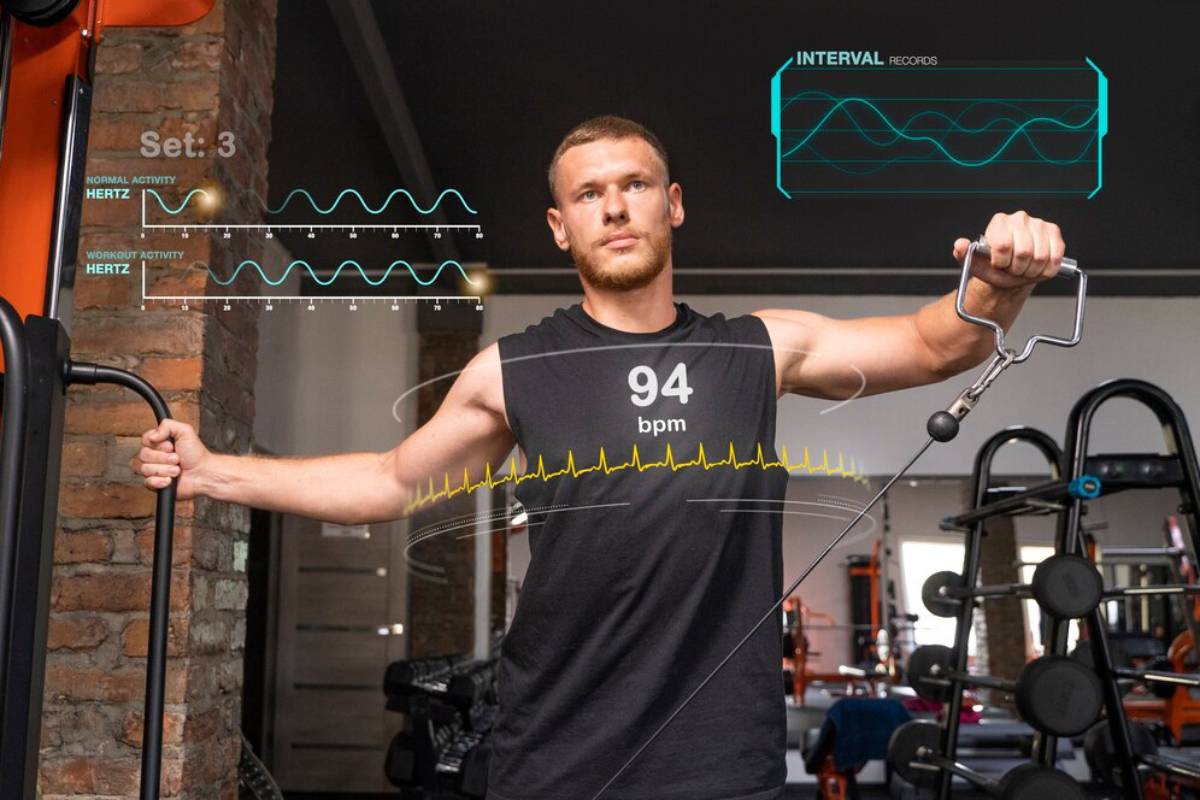 Man exercising in a gym with cable pulley while digital overlays show heart rate and other workout data.